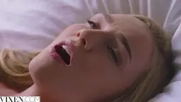 Kendra liegt nackt im Bett, Mund geöffnet, weiße Laken