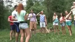 Nackte Rothaarige tanzt mit Freunden auf Waldlichtung