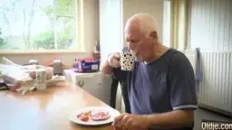 Mann mit Tasse an Küchentheke sitzend