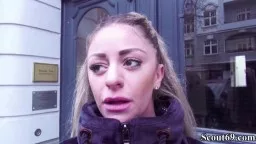 Blonde Frau im Parka vor dunkler Haustür