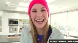 Junge Frau mit pinker Mütze lacht in heller Küche