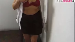 Stehende reife Frau in rotem BH und braunem Rock
